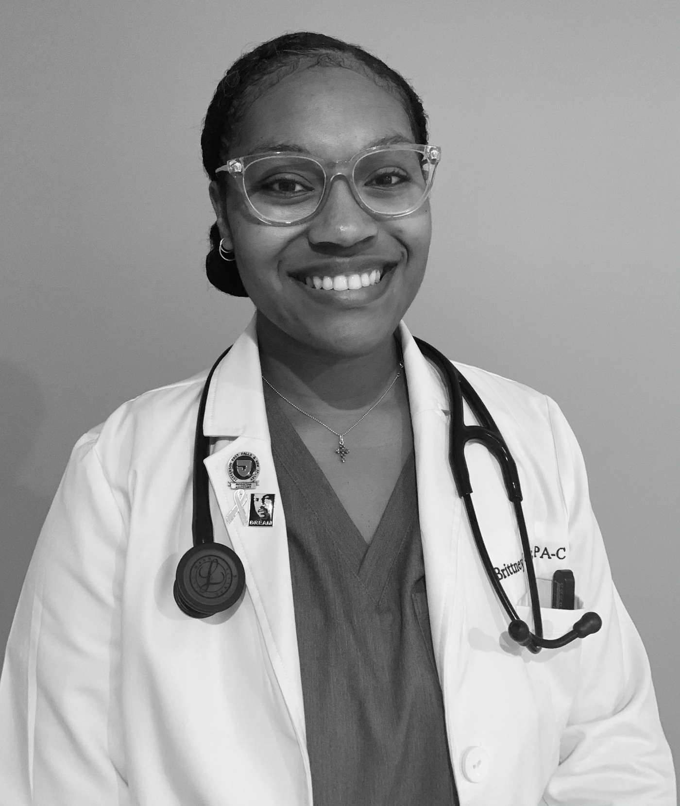 Brittney Jones smiling in a white clinical coat with a stethoscope